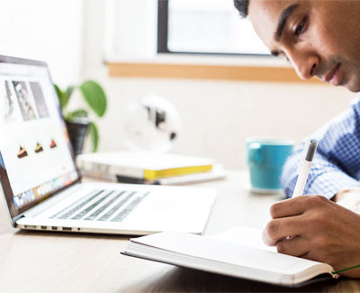 Worker writing in journal during meeting