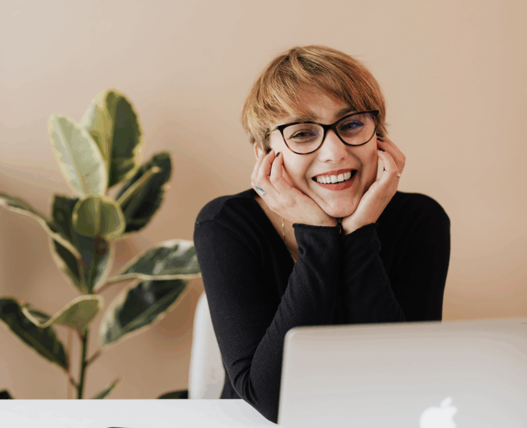 Woman smiling looking up from laptop
