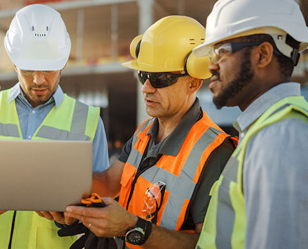 Diverse Team of Specialists Use Laptop Computer on Construction Site. Real Estate Building Project with Civil Engineer, Architectural Investor, Businesswoman and Worker Discussing Blueprint Plan