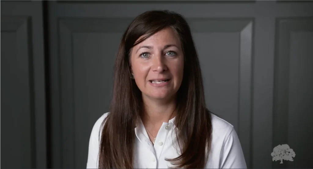 image of a woman in a white button-down shirt speaking to the camera, placeholder image for the Oakbridge Partner Success Story video