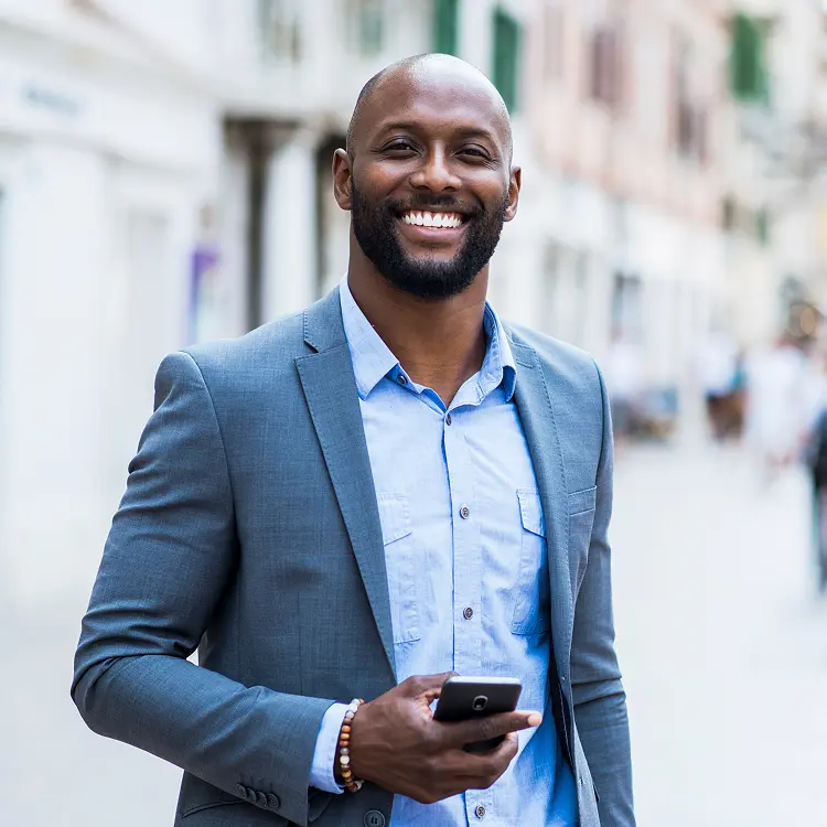 Man in suit looking up from phone